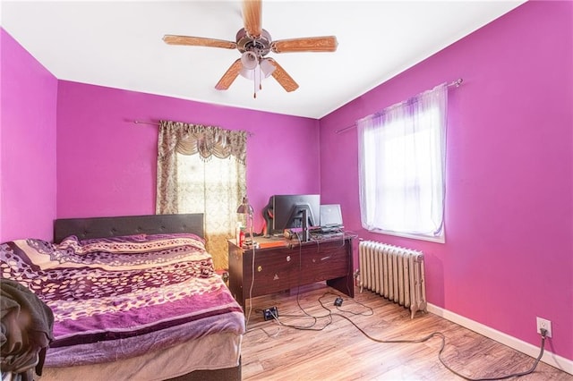 bedroom featuring radiator, ceiling fan, and light hardwood / wood-style floors