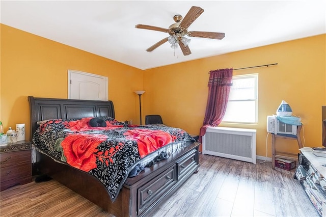 bedroom with radiator, ceiling fan, and light hardwood / wood-style floors