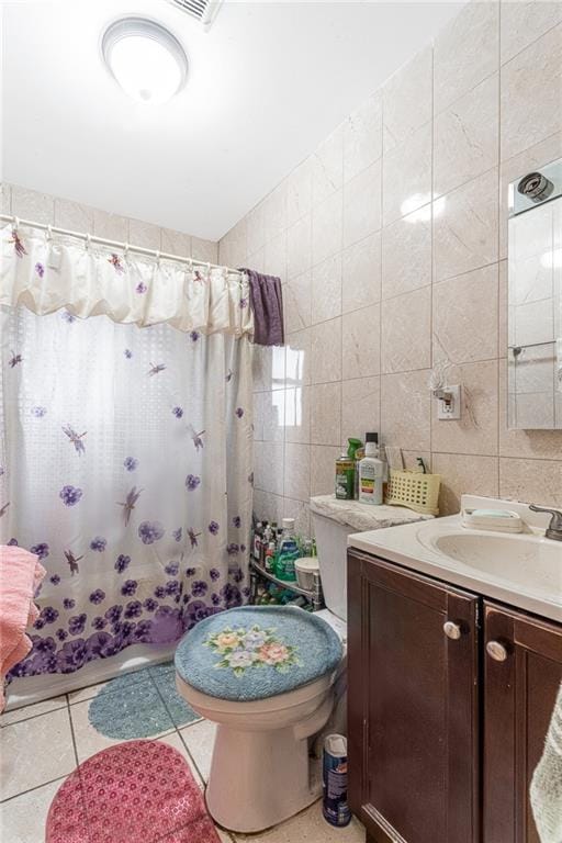 full bathroom featuring shower / bathtub combination with curtain, tile patterned floors, toilet, vanity, and tile walls