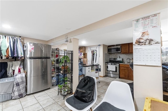 kitchen with tasteful backsplash, light tile patterned floors, and stainless steel appliances