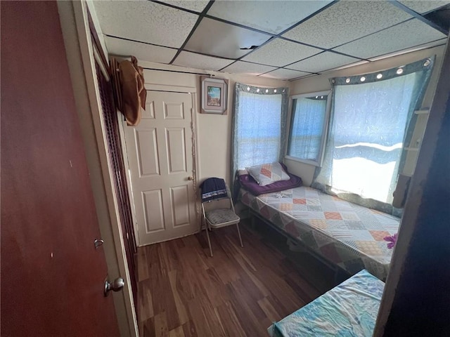 bedroom with a paneled ceiling and hardwood / wood-style floors