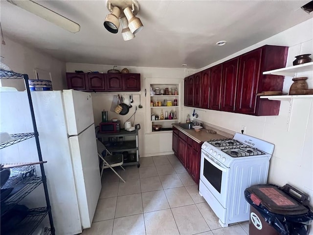 kitchen featuring light tile patterned floors, white appliances, and built in shelves