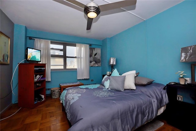 bedroom with ceiling fan and dark parquet flooring