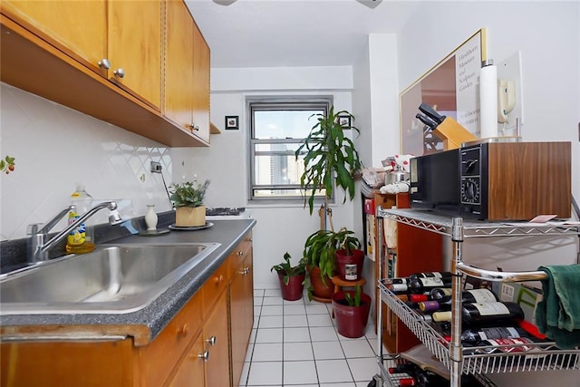 kitchen featuring tasteful backsplash, sink, and light tile patterned floors