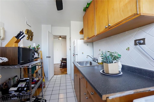 kitchen featuring light tile patterned flooring, ceiling fan, sink, and decorative backsplash