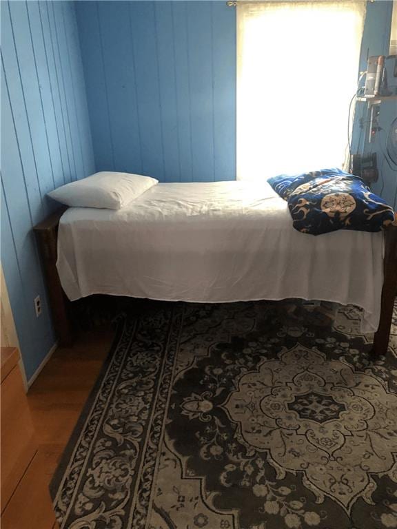 bedroom featuring wood walls