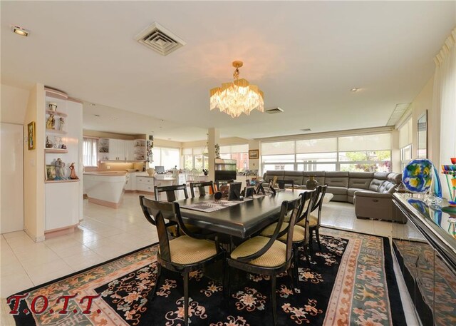 dining space with a chandelier and light tile patterned flooring