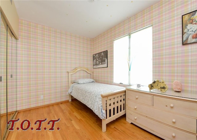 bedroom featuring multiple windows and light wood-type flooring