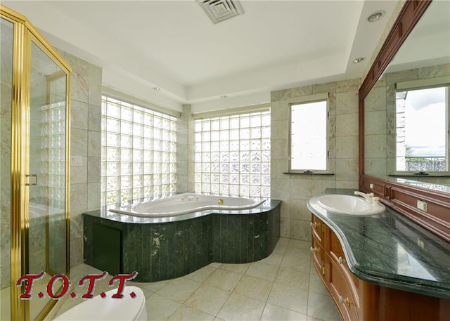 full bathroom featuring tile patterned flooring, vanity, shower with separate bathtub, tile walls, and toilet