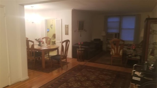 dining area with cooling unit and wood finished floors