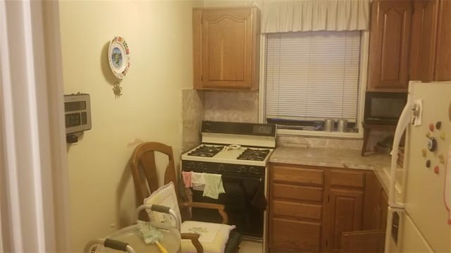 kitchen with gas range and freestanding refrigerator