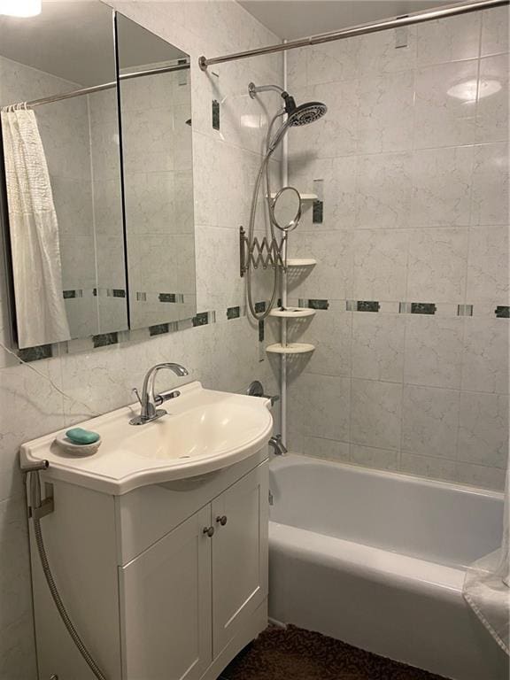 bathroom with shower / bath combination with curtain, vanity, and tile walls