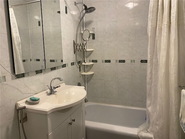 bathroom featuring vanity, tile walls, and shower / bath combo with shower curtain