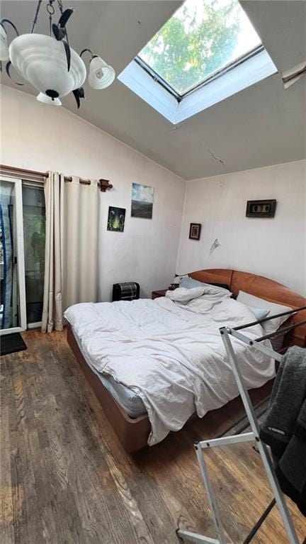 bedroom featuring vaulted ceiling with skylight and wood finished floors