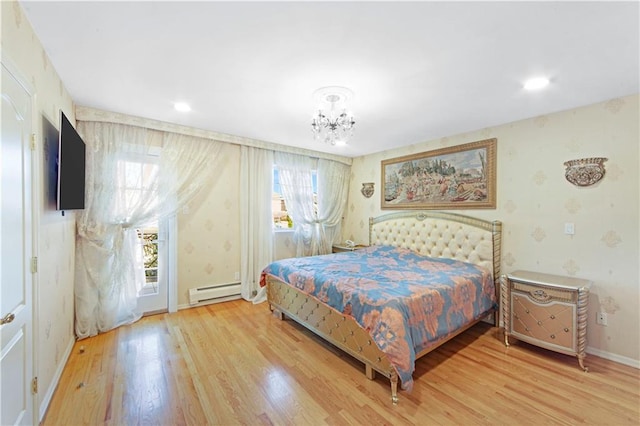 bedroom featuring wood-type flooring, multiple windows, and a baseboard heating unit