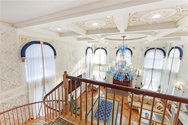 hall with beam ceiling, coffered ceiling, and an inviting chandelier