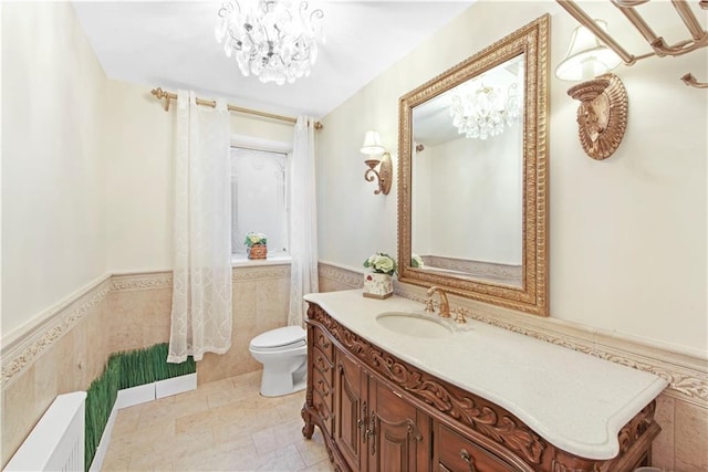 bathroom featuring vanity, toilet, tile walls, and a notable chandelier