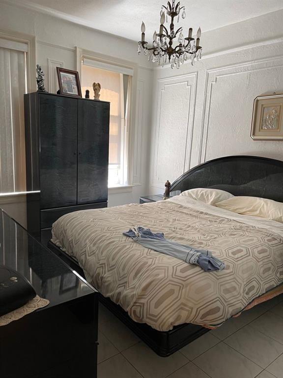 tiled bedroom with a chandelier