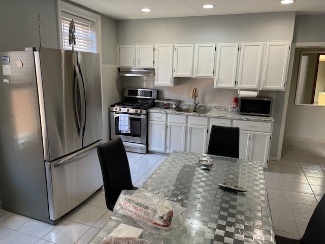 kitchen featuring appliances with stainless steel finishes, white cabinetry, sink, and tasteful backsplash