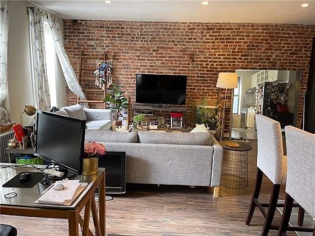 living room featuring brick wall and hardwood / wood-style floors