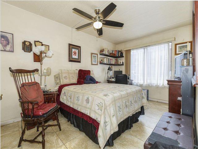 tiled bedroom featuring ceiling fan