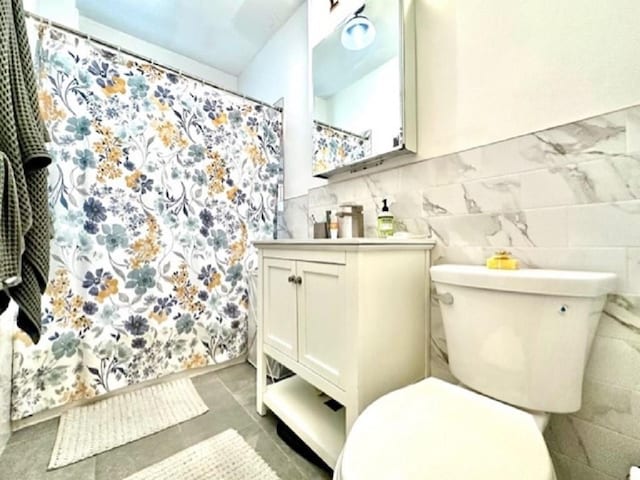 8020 4th Ave Unit D5, Brooklyn, NY 11209 - bathroom featuring toilet, vanity, a shower with curtain, tile walls, and tile patterned floors