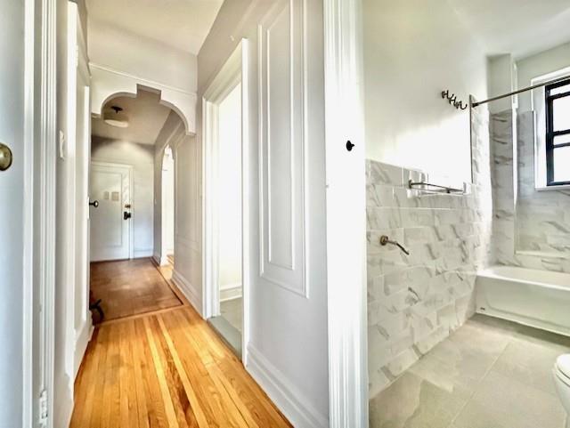 8020 4th Ave Unit D5, Brooklyn, NY 11209 - bathroom featuring toilet, wood finished floors, and  shower combination