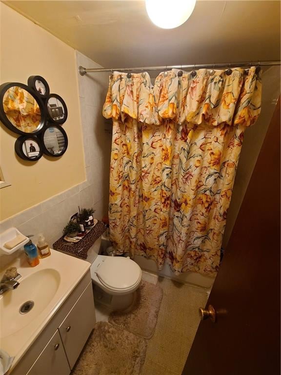 full bathroom with vanity, tile walls, shower / tub combo, and toilet