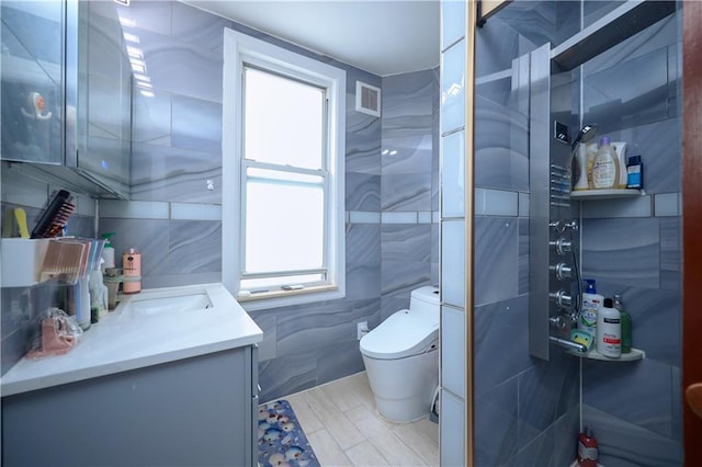 bathroom with vanity, tile walls, and toilet