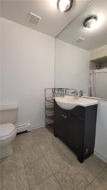 bathroom with vanity, toilet, and a baseboard heating unit