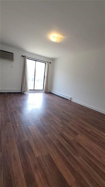 empty room featuring a wall mounted AC, dark wood-type flooring, and a baseboard radiator