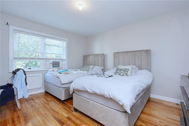 bedroom with cooling unit and light wood-type flooring