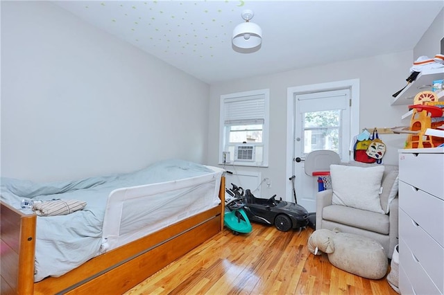 bedroom featuring light hardwood / wood-style floors and cooling unit