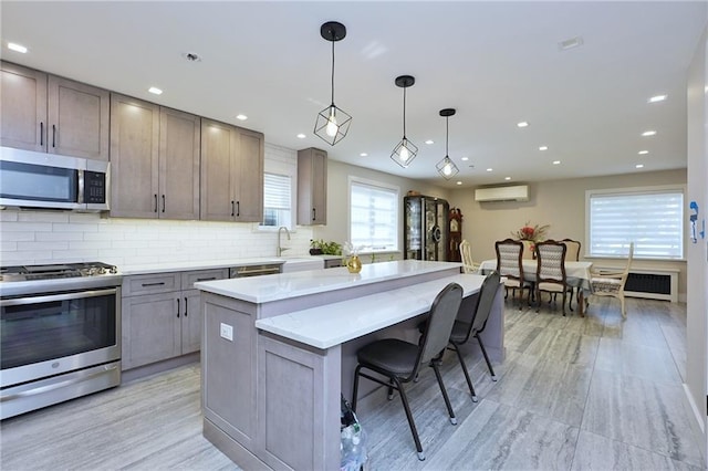 kitchen featuring radiator, hanging light fixtures, stainless steel appliances, backsplash, and a kitchen island