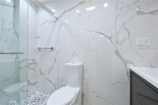 full bath featuring vanity, a shower stall, toilet, and tile walls