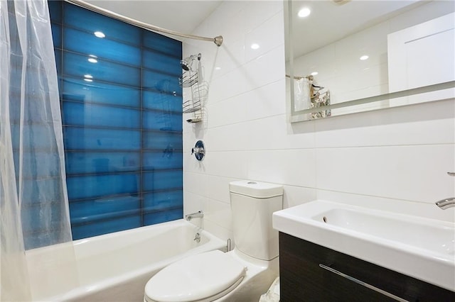 full bathroom featuring shower / bath combo with shower curtain, vanity, tile walls, and toilet