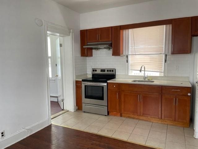 kitchen featuring electric stove, sink, tasteful backsplash, and light wood-type flooring