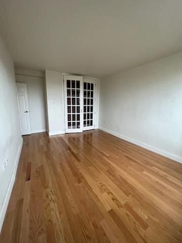 unfurnished room featuring baseboards and wood finished floors