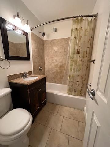 full bath featuring tile patterned flooring, shower / bath combination with curtain, toilet, and vanity