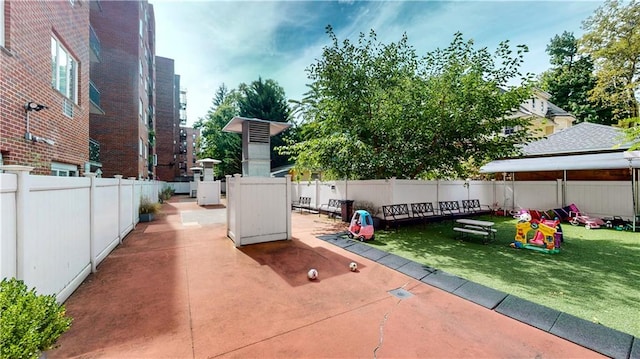 view of patio with a playground and a fenced backyard