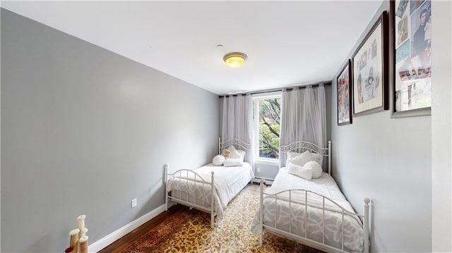 bedroom with baseboards and wood finished floors