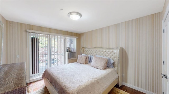 bedroom featuring wallpapered walls and baseboards