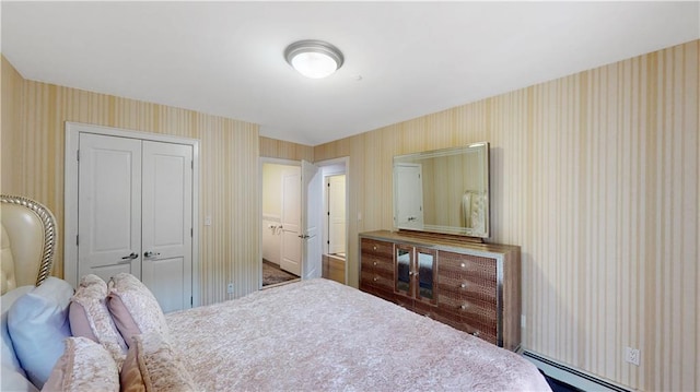 bedroom featuring a closet, baseboard heating, and wallpapered walls