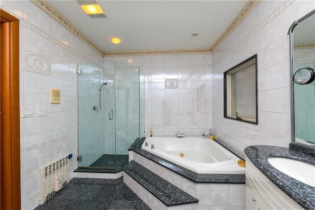 bathroom with vanity, tile walls, and shower with separate bathtub