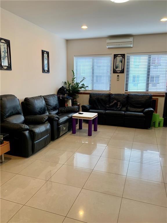 tiled living room featuring plenty of natural light, recessed lighting, and a wall mounted air conditioner