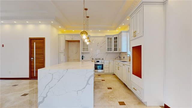 kitchen featuring white cabinetry, stainless steel oven, tasteful backsplash, light stone counters, and pendant lighting