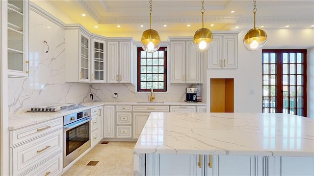 kitchen with sink, french doors, light stone counters, pendant lighting, and appliances with stainless steel finishes