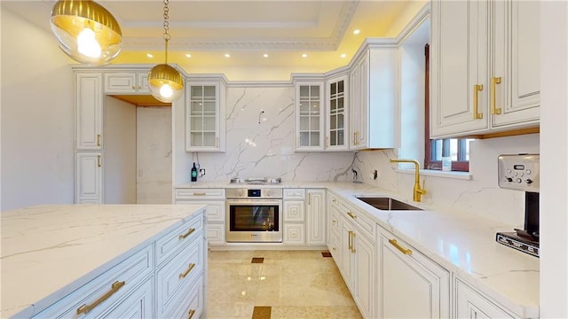 kitchen with white cabinets, sink, hanging light fixtures, light stone countertops, and appliances with stainless steel finishes