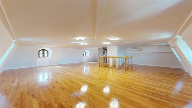 bonus room with light hardwood / wood-style floors and a wall mounted AC