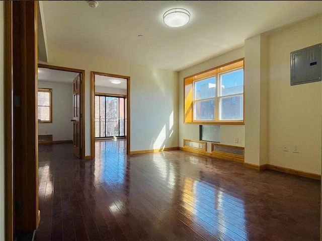 unfurnished room with electric panel and dark hardwood / wood-style flooring